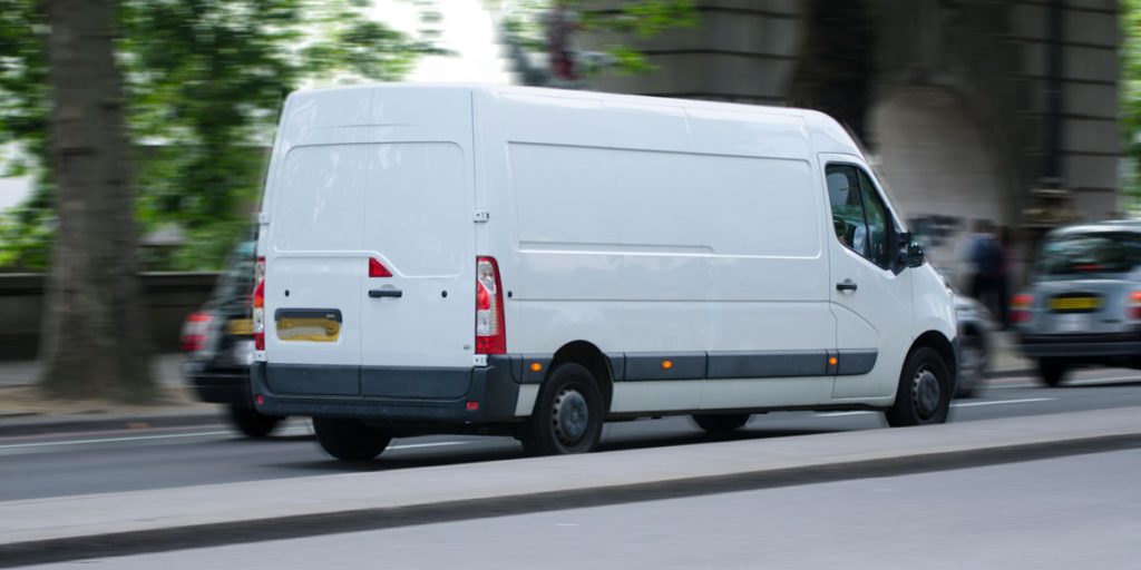 White moving van with blurred motion on the road